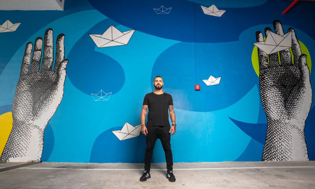 Rigo León with one of his large-scale mural creations
