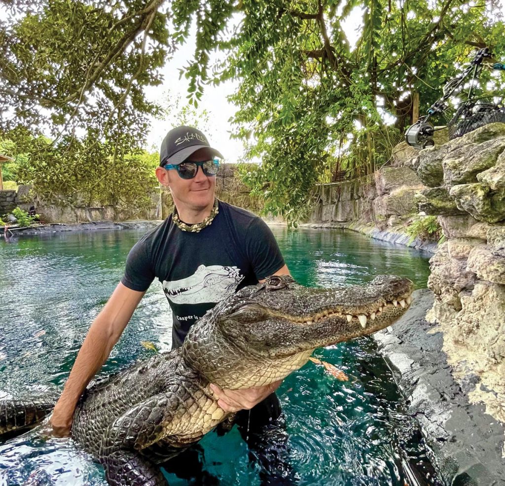 Wildlife biologist and alligator trainer Chris Gillette poses with Casper.