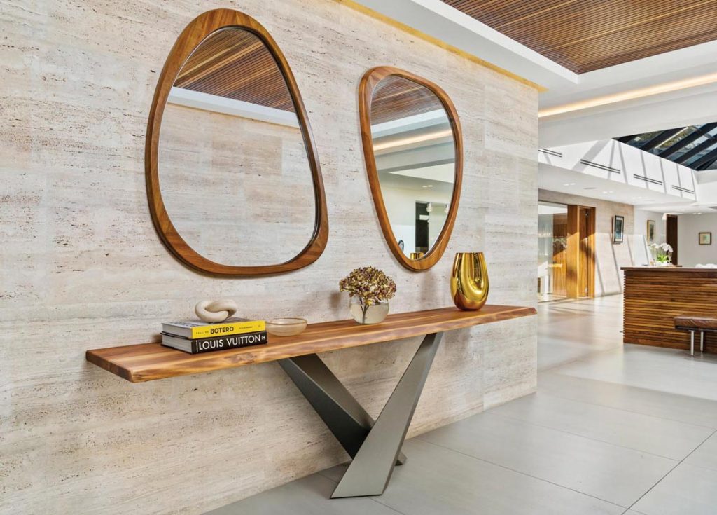 A pair of mirrors and a sleek console table welcome guests in the foyer. Photo by Zoltan Present