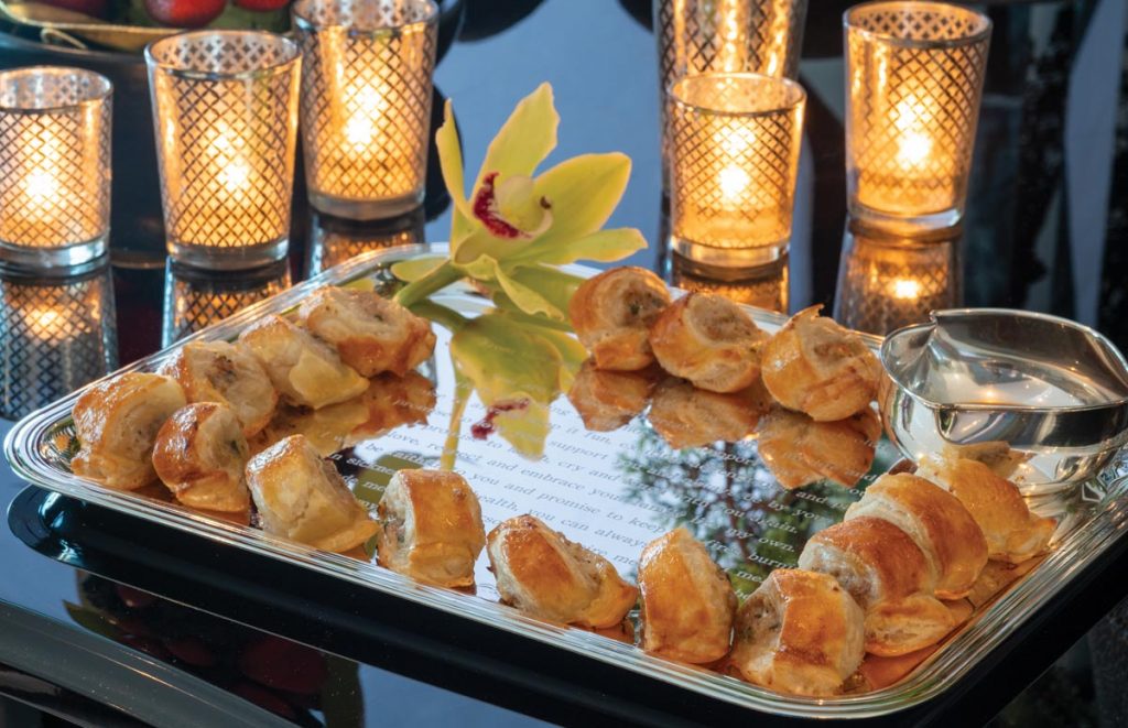Homemade sausage rolls, one of Cowie’s most treasured family recipes, are served on a Christofle silver tray engraved with his and his husband’s 2020 wedding vows. Photo by Jerry Rabinowitz